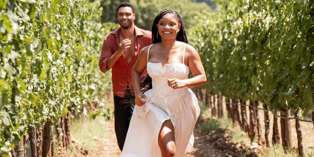 Regé-Jean Page and Halle Bailey run through a vineyard in You, Me & Tuscany. (Photo credit: Universal Pictures)